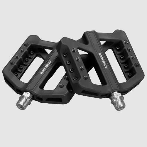 Black bicycle pedals with metallic axles on a dark background, featuring product details text.
