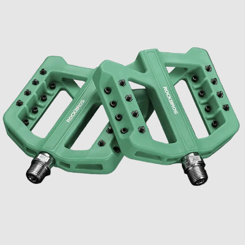 Green bicycle pedals with text detailing features on a dark background